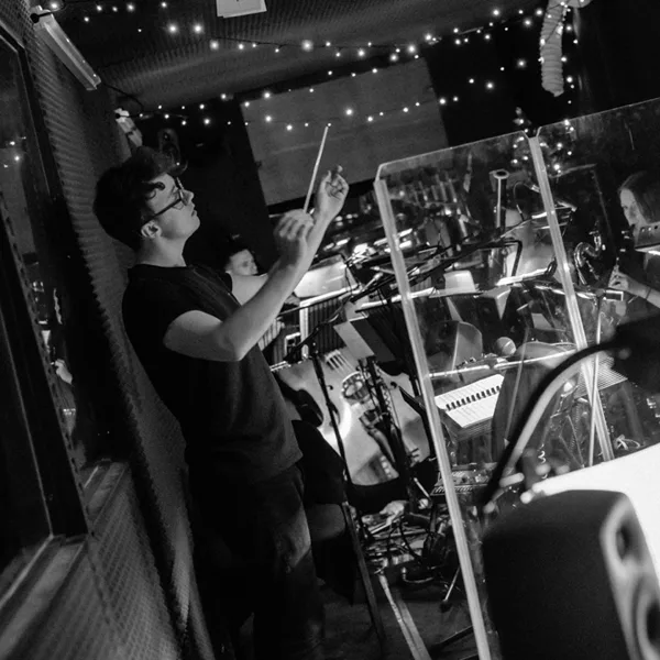 Luke Holman conducting from the wings at Oliver!, in black and white